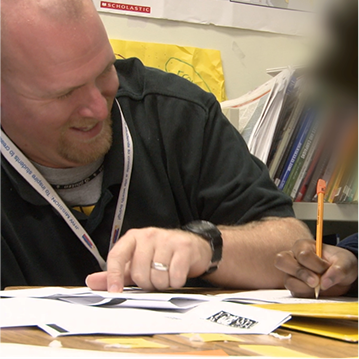 Male teacher working with a student