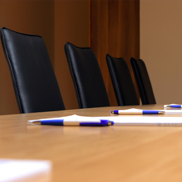 Chairs, pens and notebooks in a board room